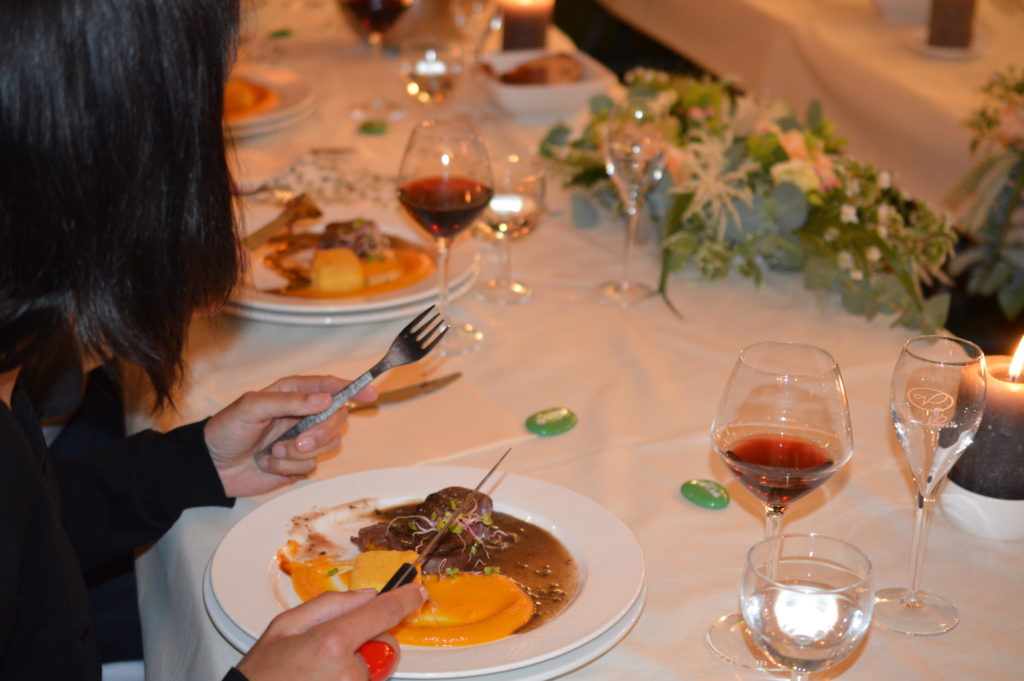 Dégustation d'un filet de boeuf et d'une purée de patate douce et  jus de viande corsé, le tout accompagné d'un vin rouge servi par un maître d'hôtel 