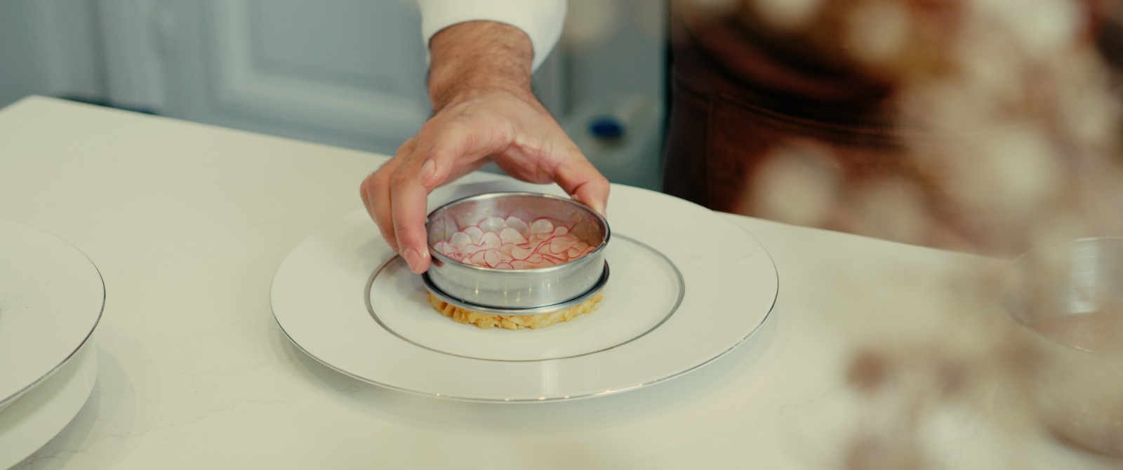 Fresh fish tartare, paired with finely sliced radishes, fresh herbs, and a touch of olive oil and lemon, elegantly presented on a plate