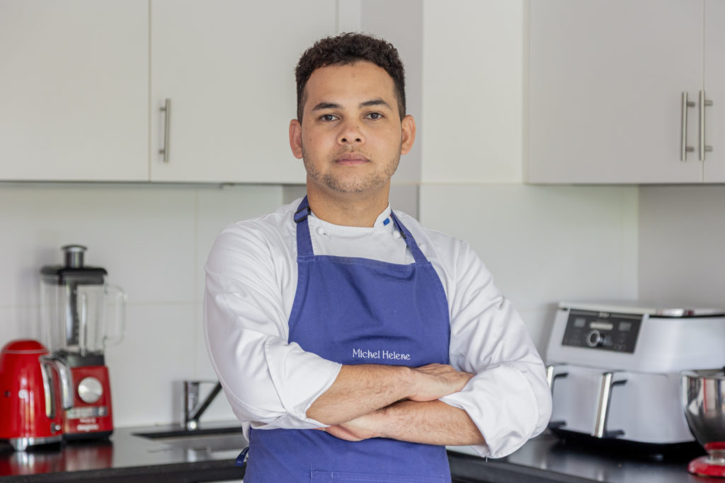Portrait du chef Michel Hélène en cuisine avec un tablier bleu