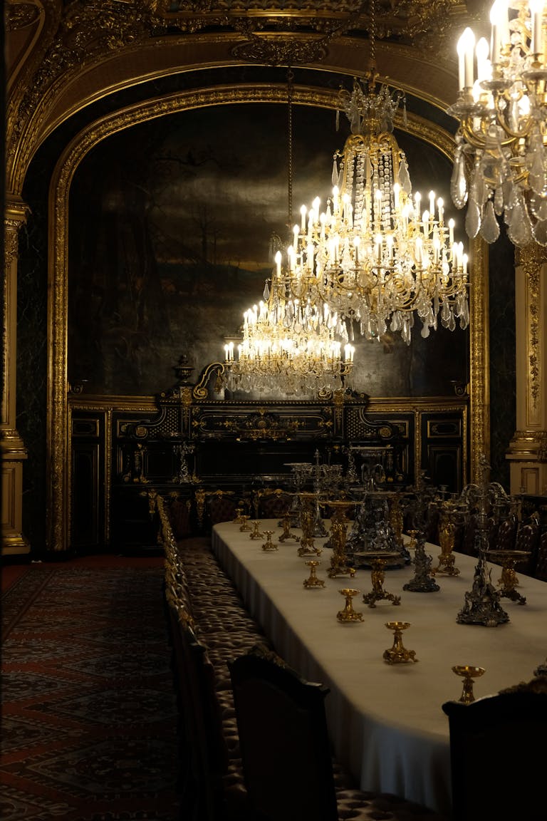 Salle à manger luxueuse à Paris avec des lustres exquis et une décoration élégante, mettant en valeur la richesse et la grandeur