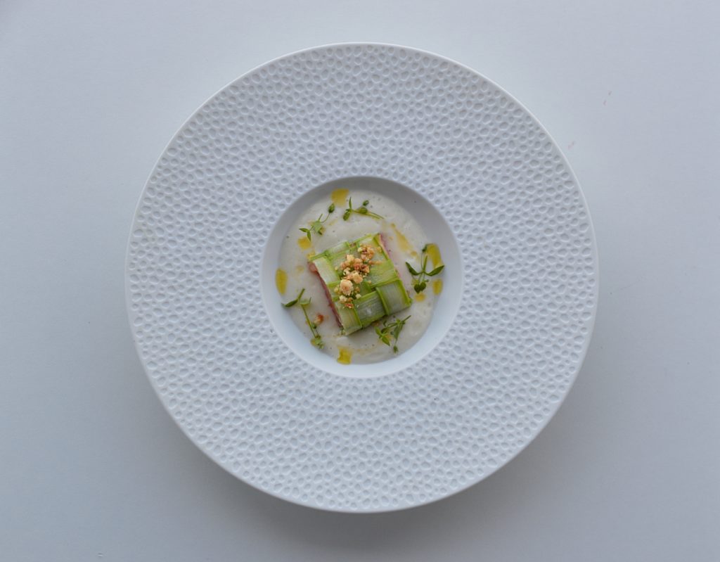 une assiette de truite en sauce et une emulsion d'asperges blenches
