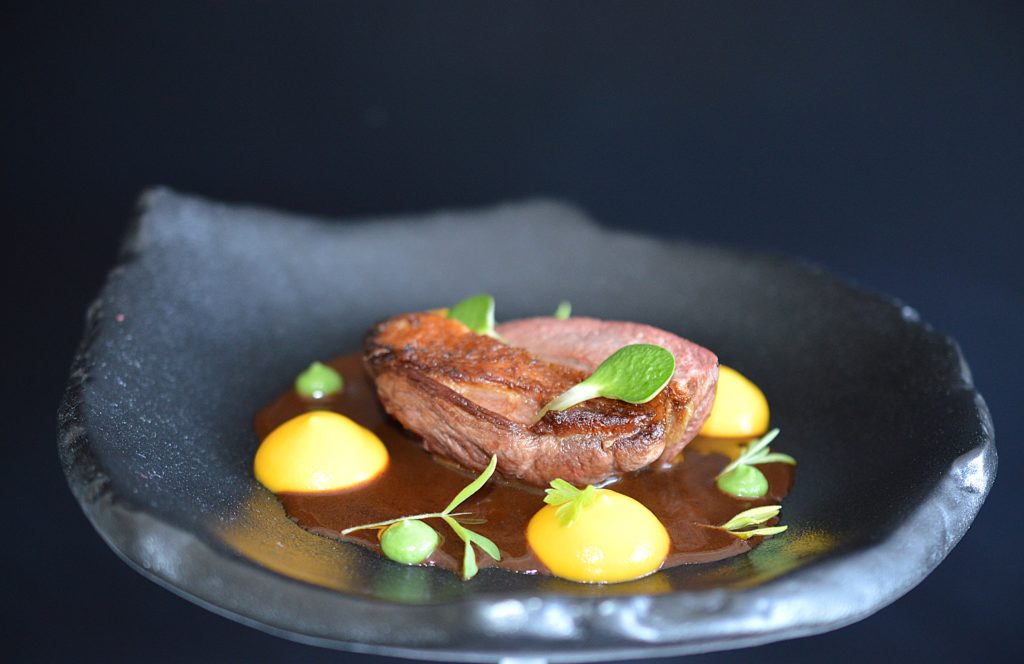 Une assiette de pigeon joliment dressé par un chef gastronomique