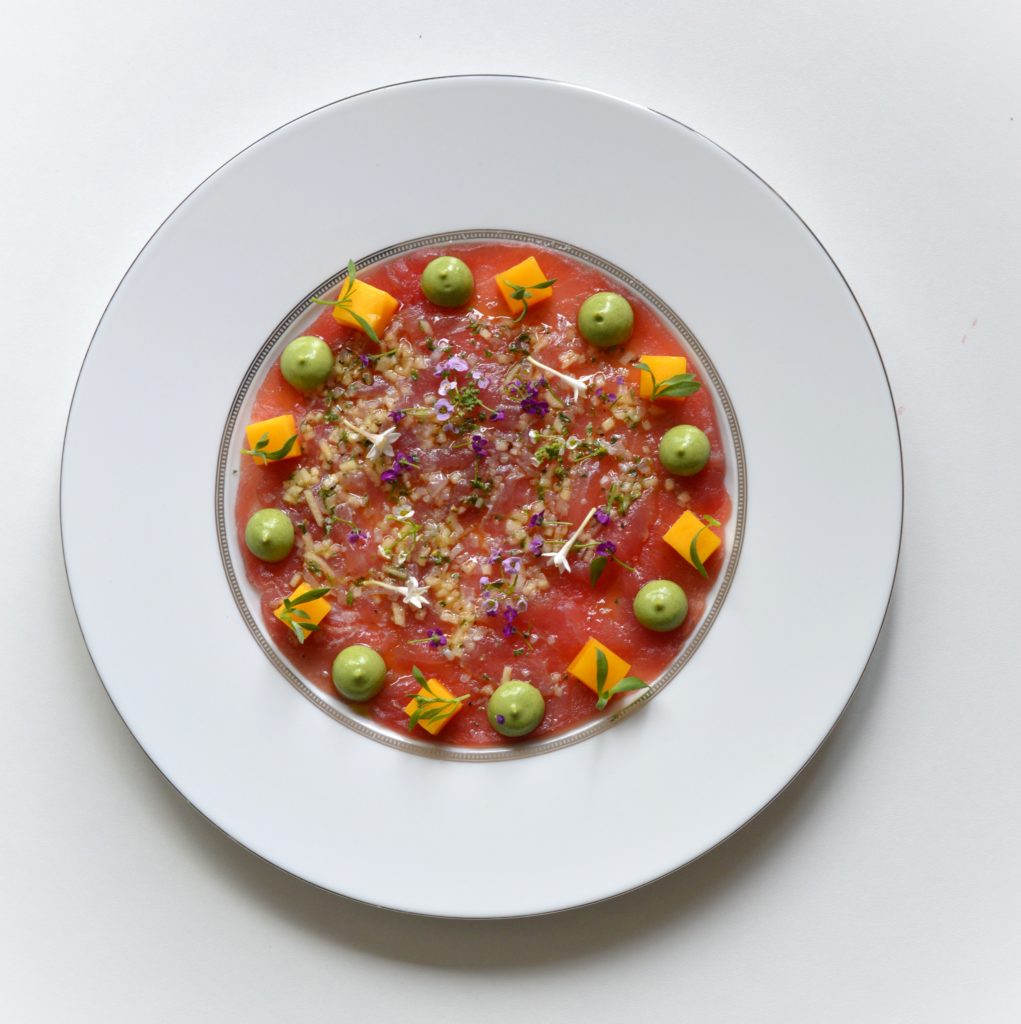 Un carpaccio de thon rouge dressé sur assiette blanche