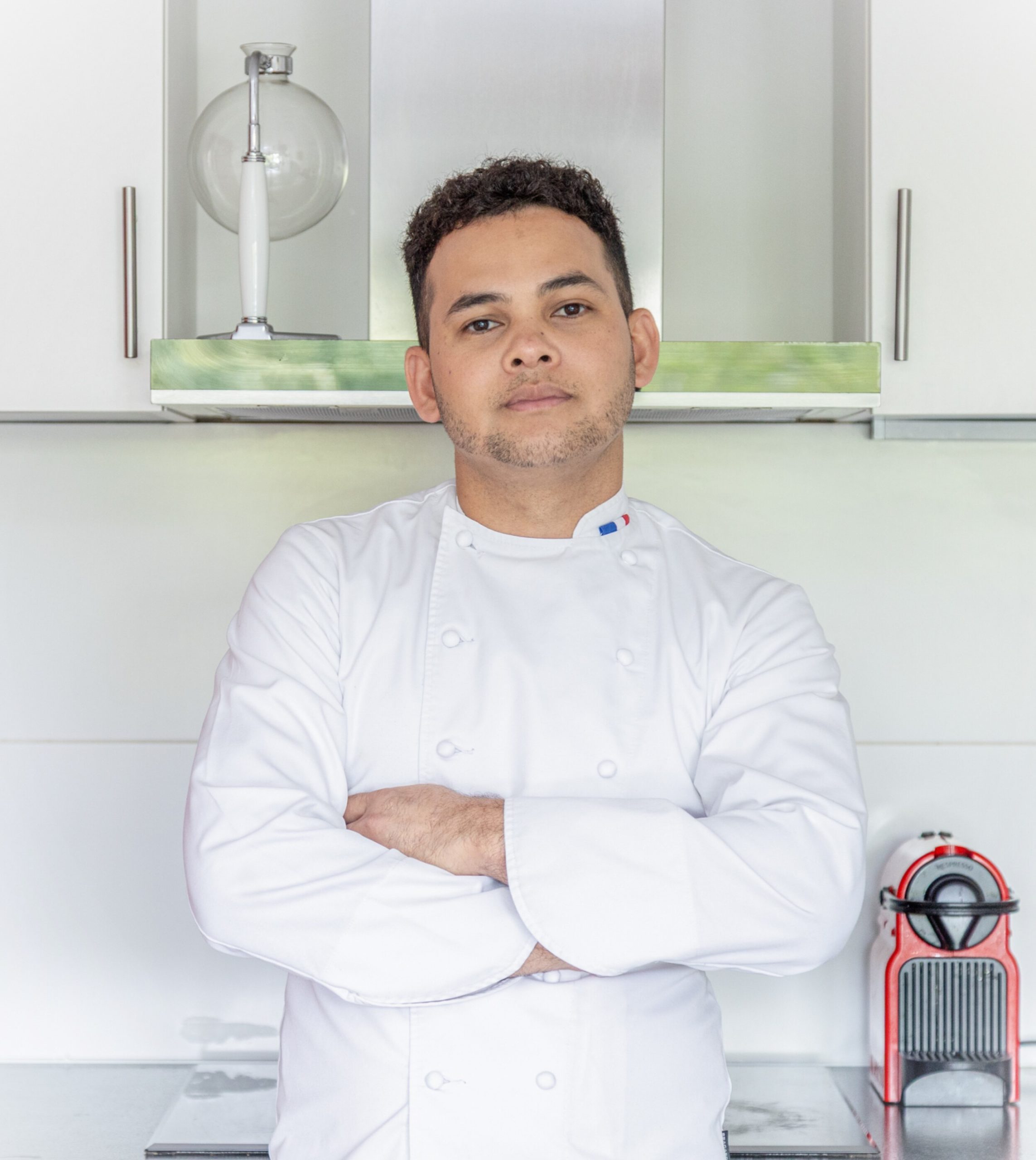 Un portrait du chef Michel Hélène avec une veste blanche de grand chef dans la cuisine 