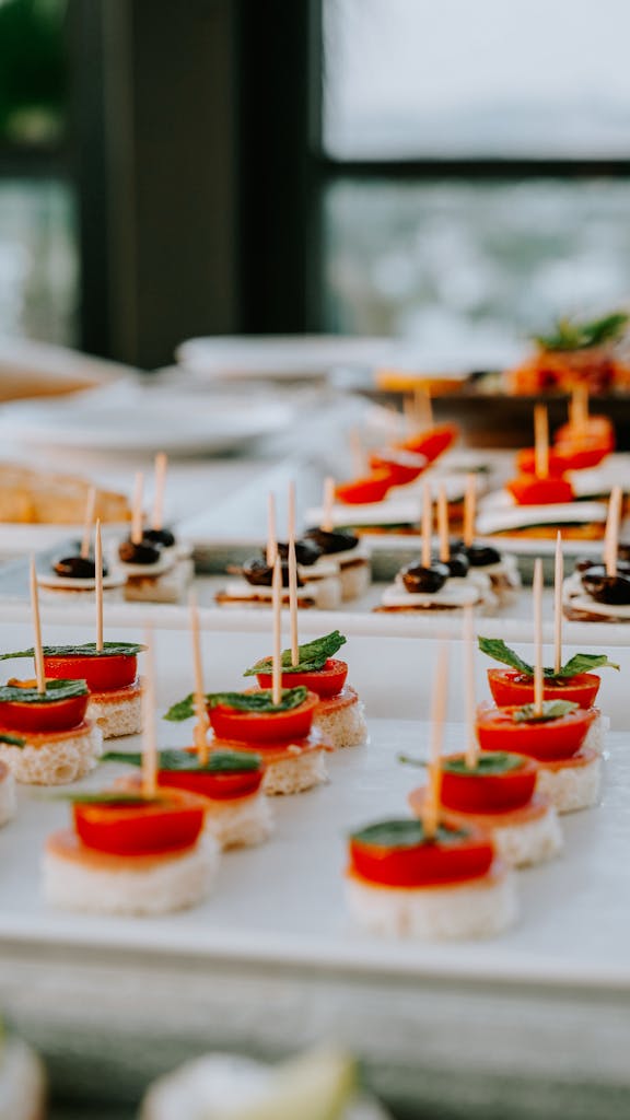 Des amuse-bouche gourmands composés de tomates, d'olives et d'herbes fraîches, présentés sur un plateau festif.