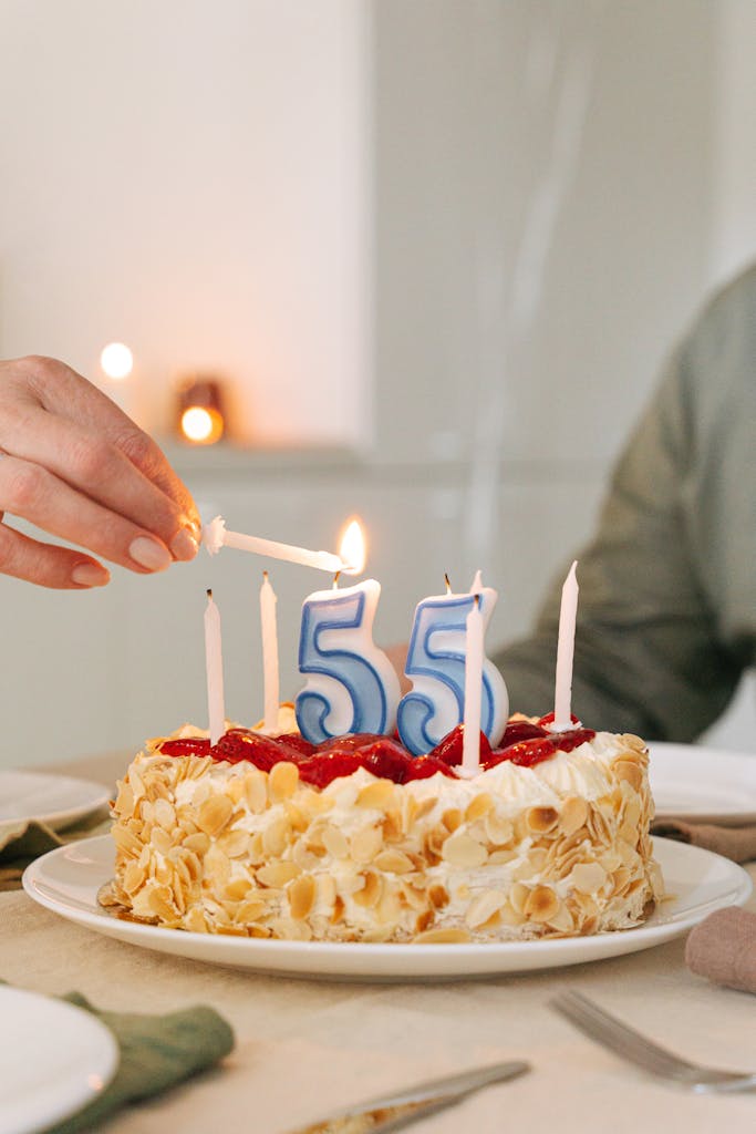 Un délicieux gâteau d'anniversaire pour un 55e anniversaire, orné de bougies et d'amandes, prêt à être fêté.