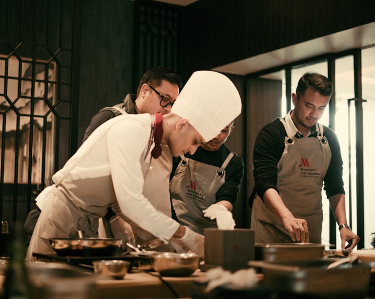 Une équipe de chefs travaillant ensemble dans la cuisine d'un d'un particulier, préparant des plats gastronomiques avec précision et savoir-faire.