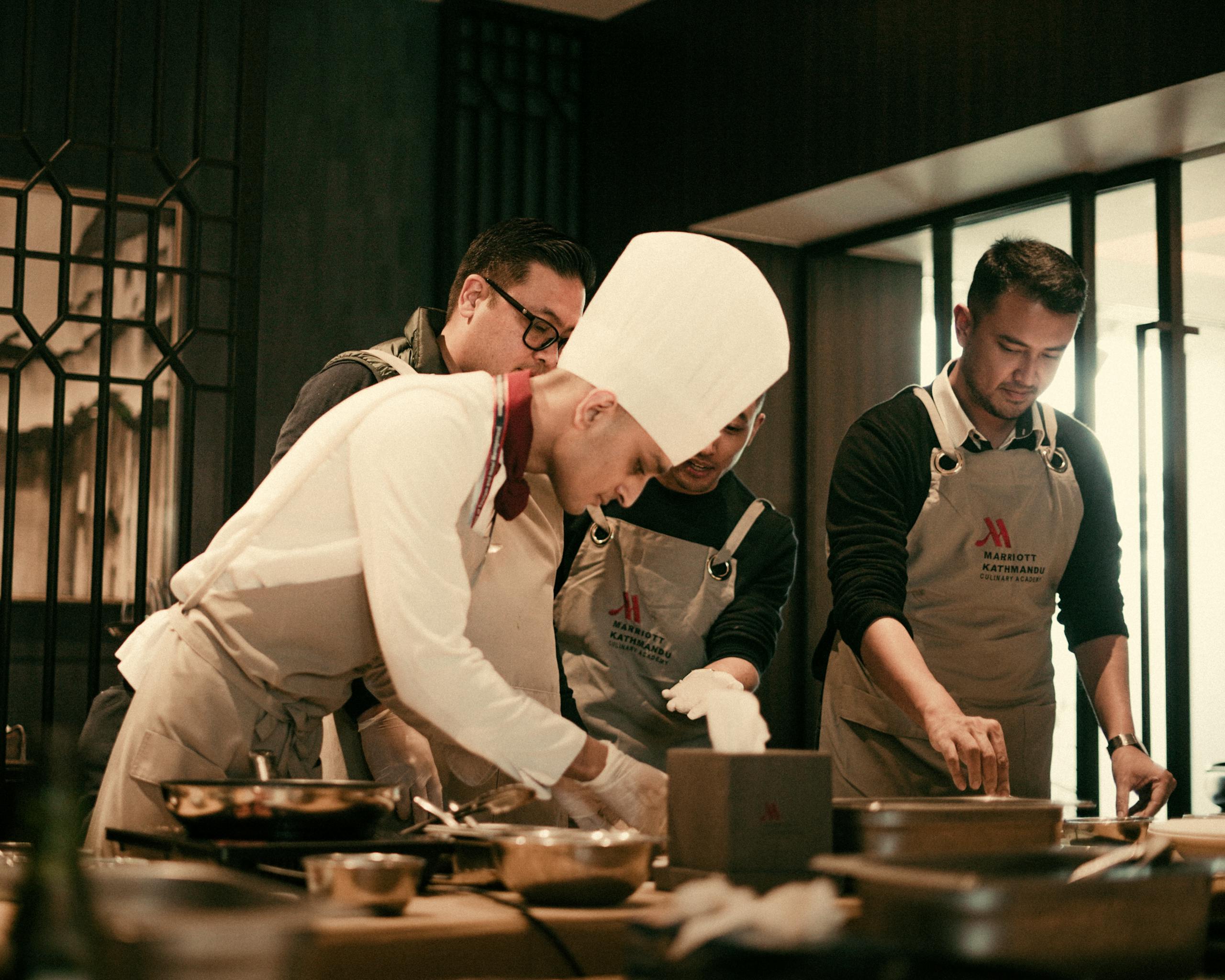 Une équipe de chefs travaillant ensemble dans la cuisine d'un d'un particulier, préparant des plats gastronomiques avec précision et savoir-faire.