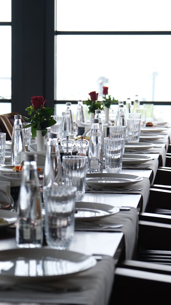 Une table élégamment dressée avec de la verrerie et des roses rouges lors d'un dîner privé